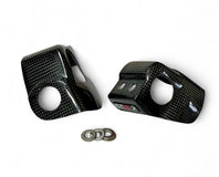 Carbon fiber car door handles with mounting rings on a white background